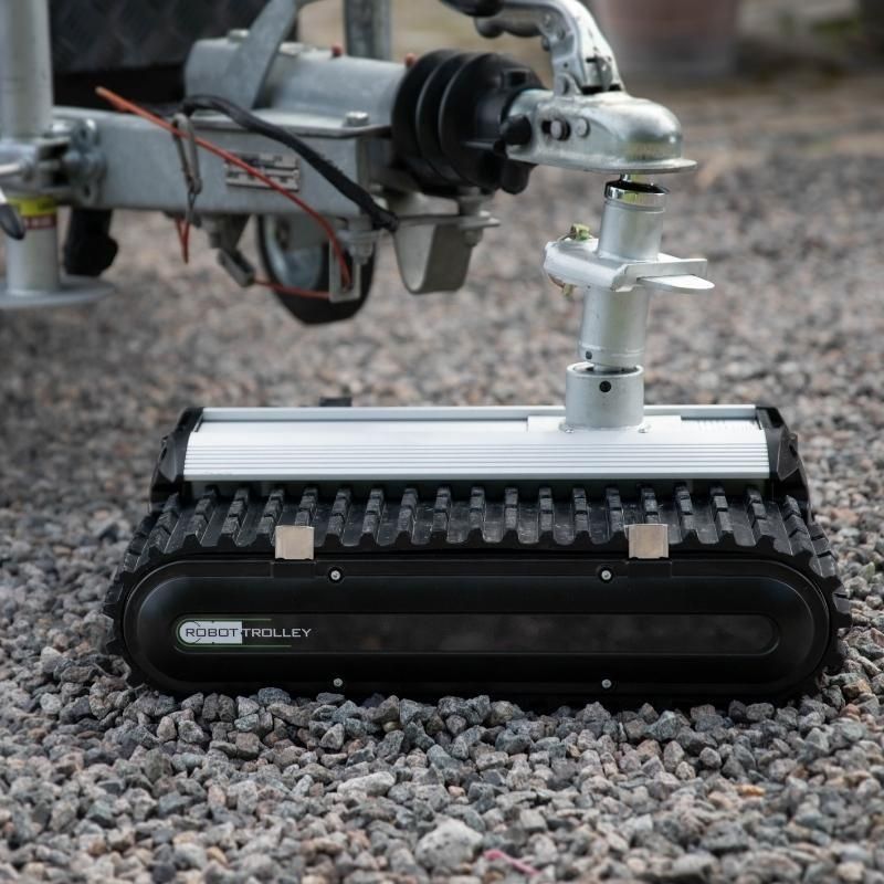 Close-up of Robot Trolley 4500 G2 Caravan Mover with textured rubber tracks on gravel.
