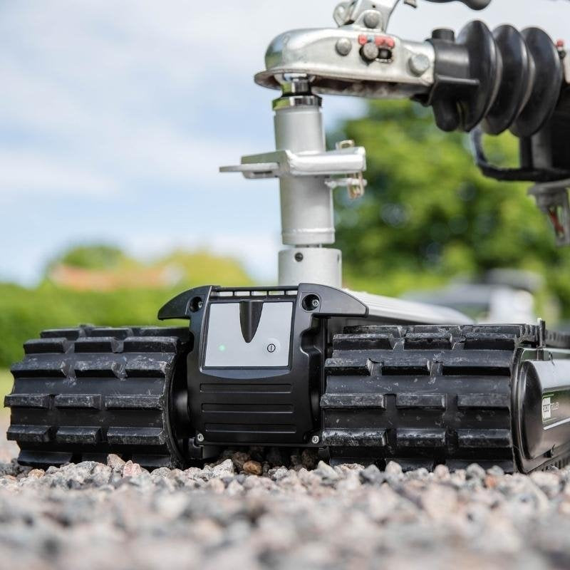 Robot Trolley 4500 G2 Caravan Mover operating on a gravel surface with vehicle coupling.