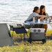 Portable power station with solar panel setup at a picnic by the river.