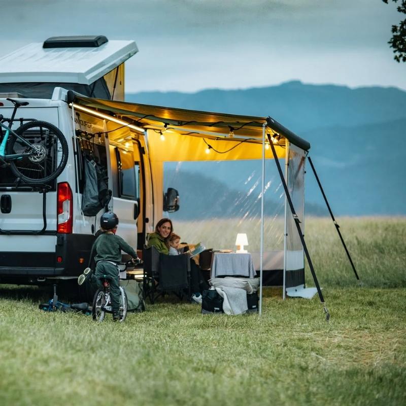 A family enjoying an outdoor camping experience with the Thule 5200 manual awning extended, offering shade and comfort.