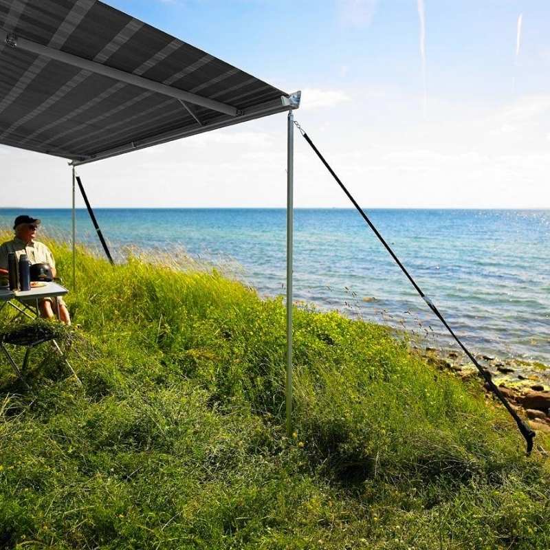 Thule hold down side strap kit securing wind-out awning on coastal campsite for added wind stability