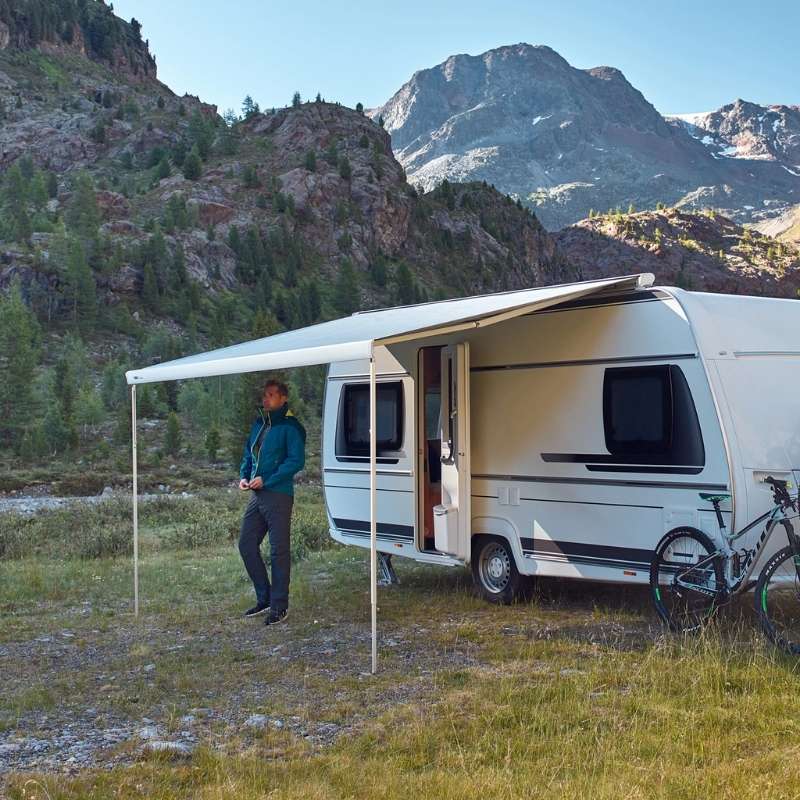 Thule Omnistor 6300 Electric 12V Awning deployed on a camper van in a breathtaking mountain landscape, offering shade and comfort in the great outdoors.