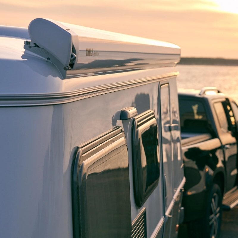 Thule Omnistor 6300 Electric 12V Awning offering shelter during a stunning sunset at a campsite, perfect for unwinding and enjoying the view.