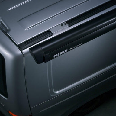 Side view of the Thule 5102 manual awning, installed on the roof of a van with a black cassette housing.